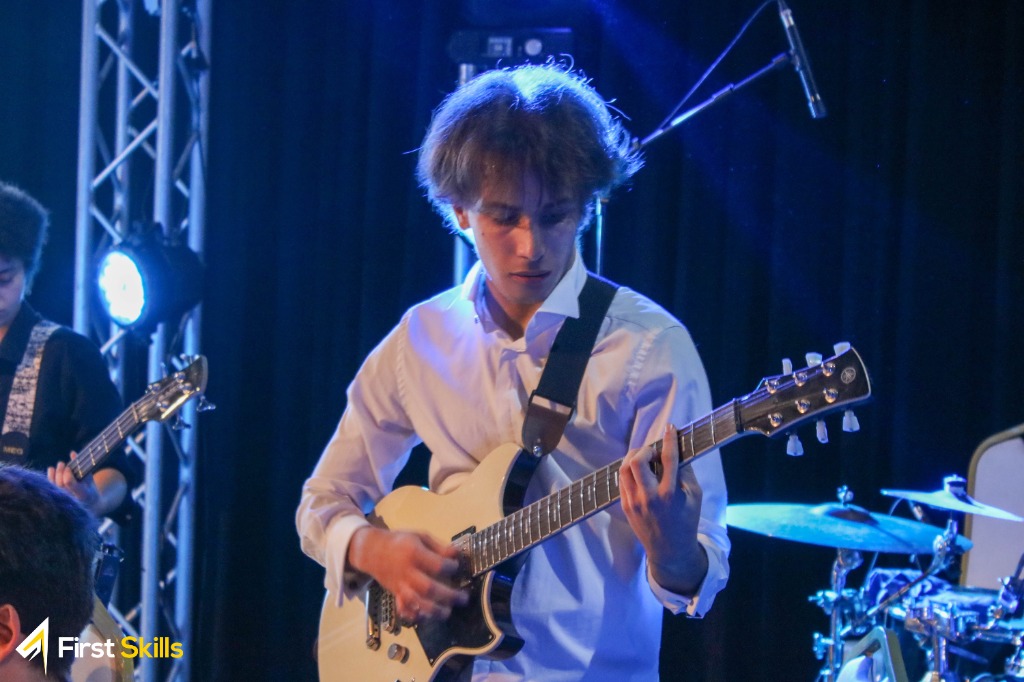 Mahdi Kammoun performing live on stage with guitar under concert lighting